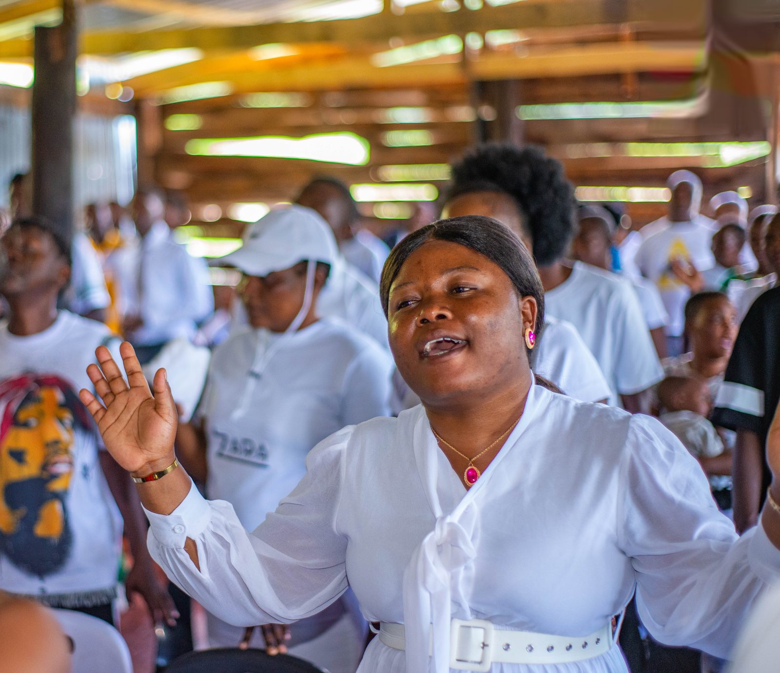 Congregation with hands raised inside the tent