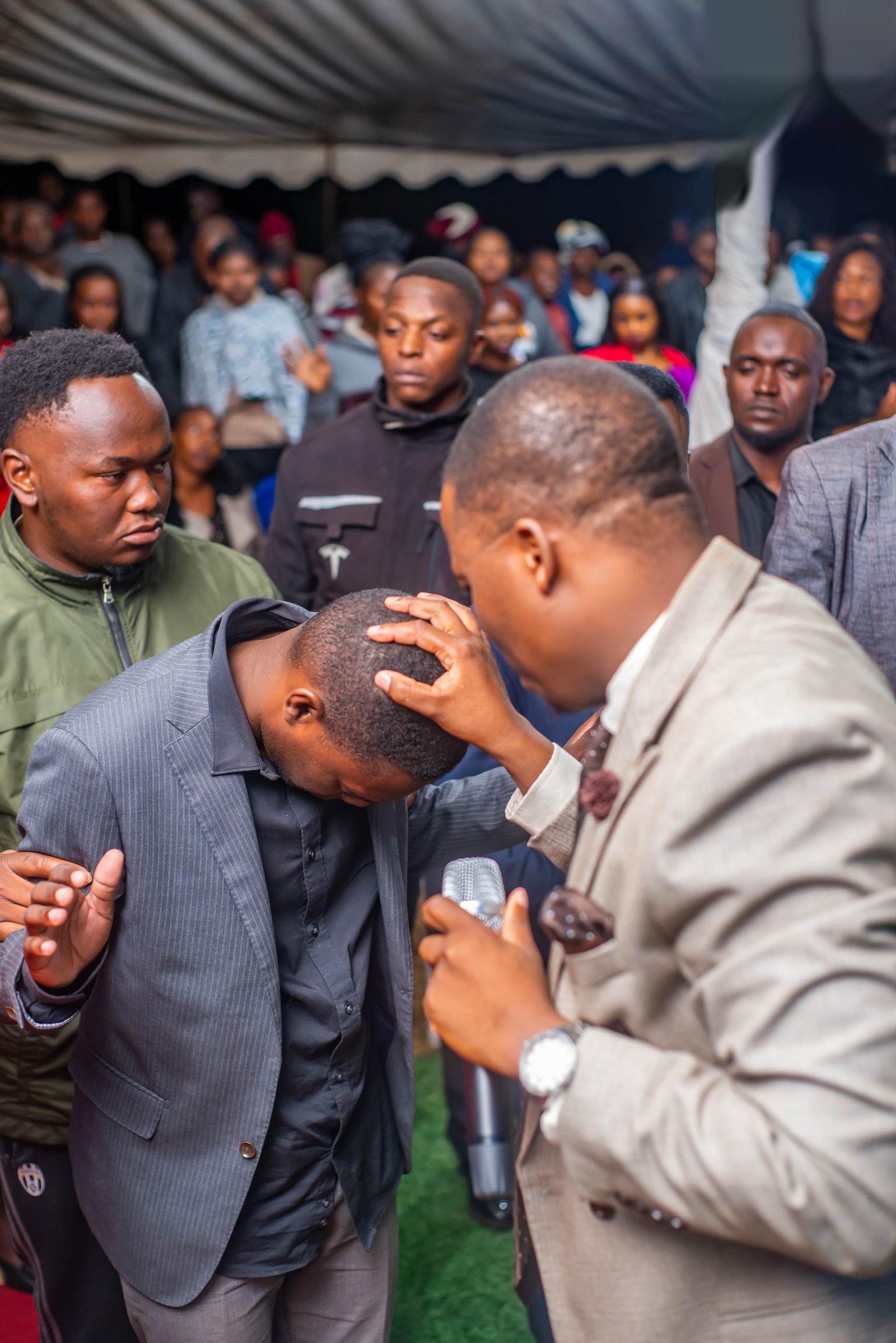 Hands laid on a man's head in blessing during prayer